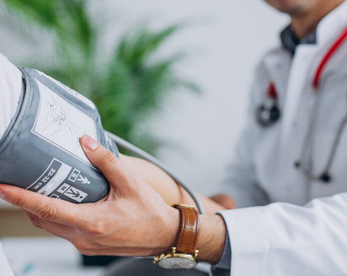 Médico afere pressão e saúde de paciente (Crédito: Freepik)